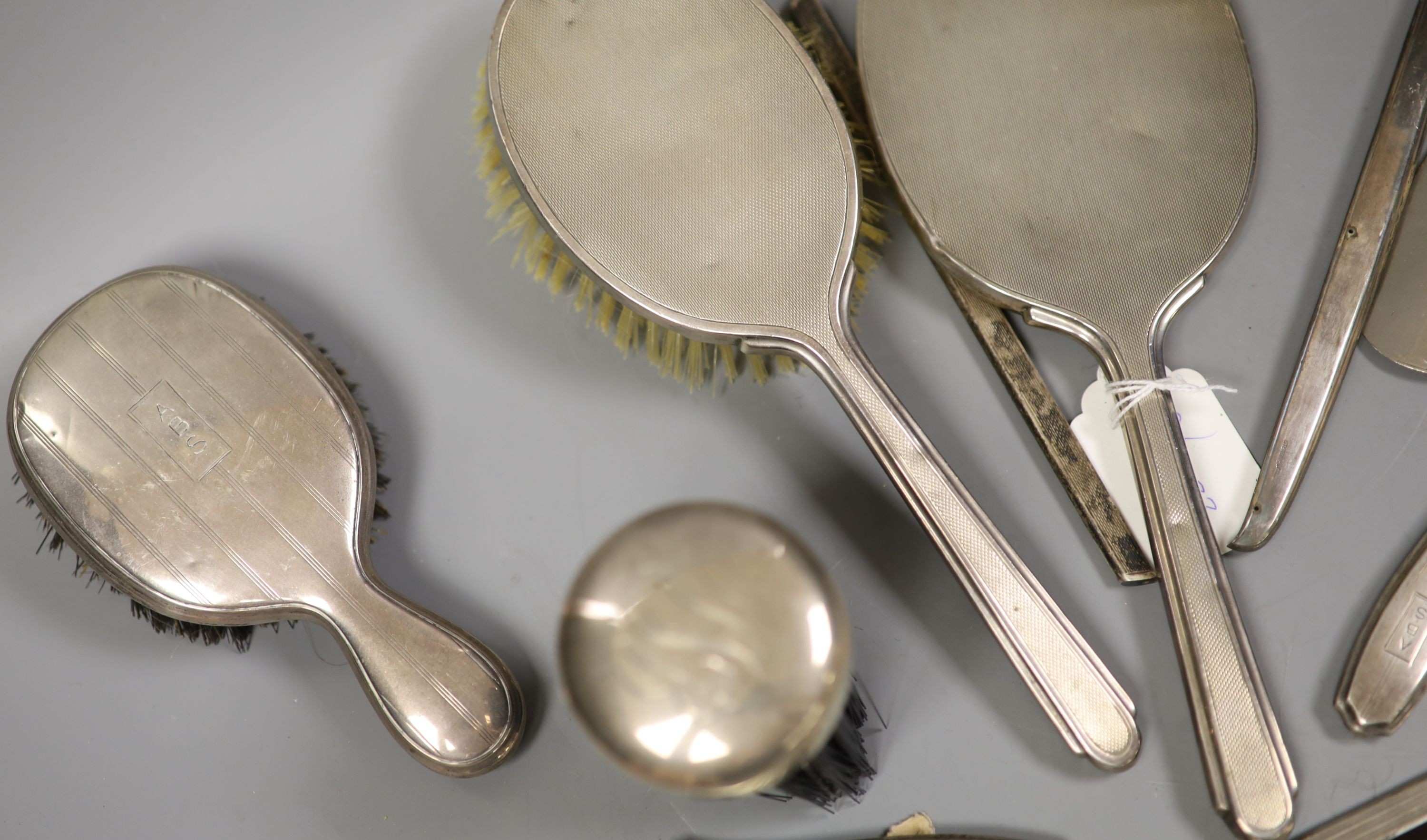 A 1940's silver mounted hand mirror and a group of other silver or sterling mounted brushes etc.